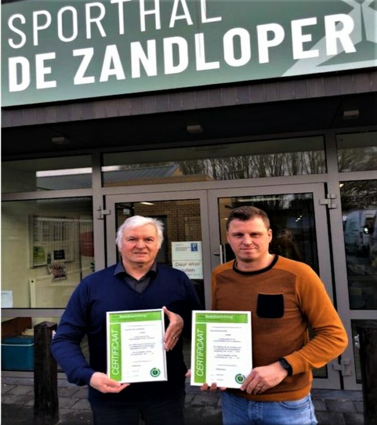 Schepen en directeur voor sporthal De Zandloper met energiecertificaten.