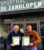 Schepen en directeur voor sporthal De Zandloper met energiecertificaten.