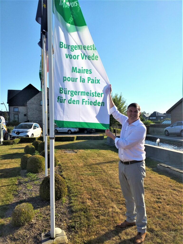 Burgemeester Soetens met vlag voor gemeentehuis Lierde